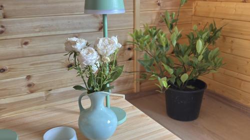 a blue vase sitting on a table with flowers at Bio-Nestlein Gartenhaus in Löffingen