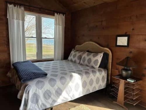 Un dormitorio con una cama grande y una ventana. en Private Cozy Waterfront Cabin, en Sealevel