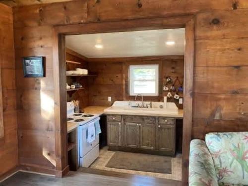 una cocina con fregadero y estufa en Private Cozy Waterfront Cabin, en Sealevel