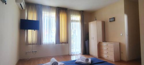 a bedroom with windows and a bed and a dresser at Къща за гости ,,Ива'' in Bŭlgarevo
