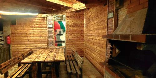a room with two wooden benches and a fireplace at Къща за гости ,,Ива'' in Bŭlgarevo