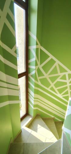 a room with green and white walls and a window at Къща за гости ,,Ива'' in Bŭlgarevo