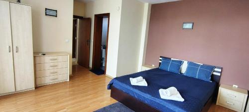 a bedroom with a bed with blue sheets and blue pillows at Къща за гости ,,Ива'' in Bŭlgarevo