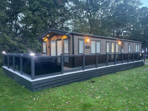 a modular house with a deck in a field at New Forest holiday lodge in New Milton