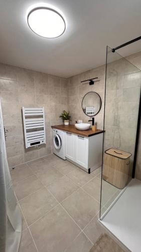 a bathroom with a sink and a washing machine at Cocon Design avec jardin privé in Aimargues