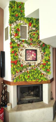 a living room with a fireplace with a flower wall at Къща за гости ,,Ива'' in Bŭlgarevo