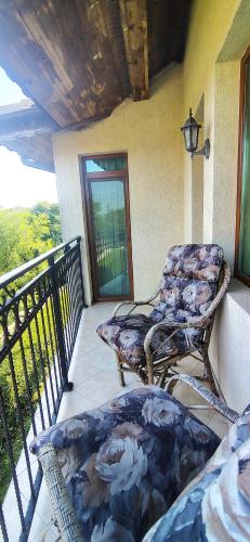 a porch with two chairs on a balcony at Къща за гости ,,Ива'' in Bŭlgarevo