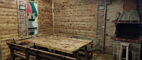 a wooden room with a table and a fireplace at Къща за гости ,,Ива'' in Bŭlgarevo