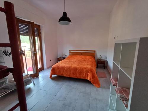 a bedroom with a bed with an orange blanket at Dimora mediterranea Fontanamare in Gonnesa