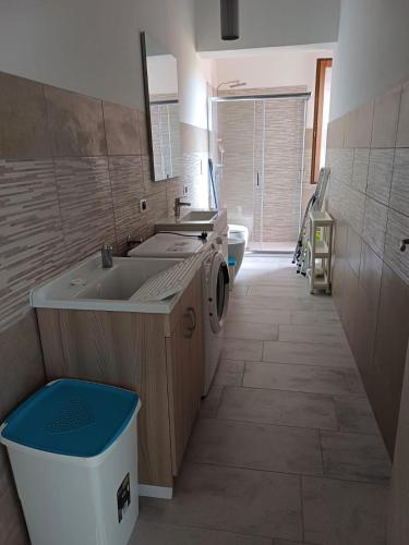 a bathroom with a sink and a washing machine at Dimora mediterranea Fontanamare in Gonnesa