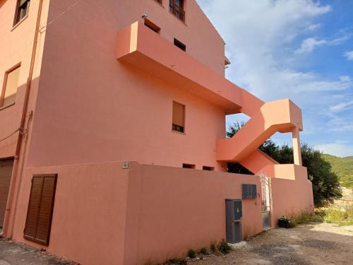 a building with a staircase on the side of it at Dimora mediterranea Fontanamare in Gonnesa