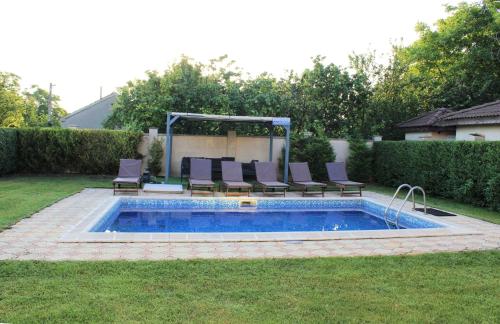 a backyard pool with chairs and a swimming pool at Къща за гости ,,Ива'' in Bŭlgarevo