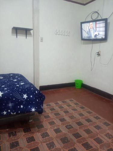 a room with a bed and a tv on a wall at Habitación Plaza Chosica in Chosica