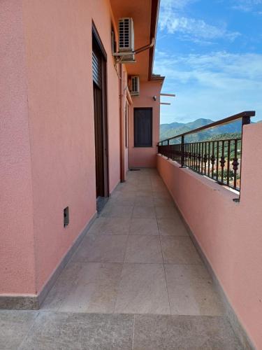 a balcony of a pink building with a walkway at Dimora mediterranea Fontanamare in Gonnesa