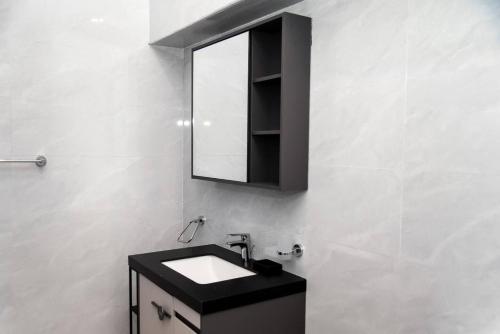 a bathroom with a black sink and a mirror at The Kottage Studio Apartment A in Accra