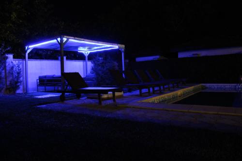 a group of benches under a canopy at night at Къща за гости ,,Ива'' in Bŭlgarevo