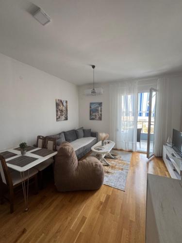 a living room with a couch and a table at Blue wave apartman in Becici