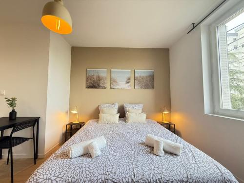 a bedroom with a large bed with two pillows at Studio Mars NEW & Cozy - Parilly Train Station in Vénissieux