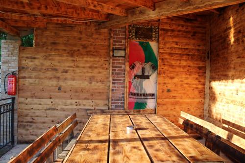 a wooden room with benches and a painting on the wall at Къща за гости ,,Ива'' in Bŭlgarevo
