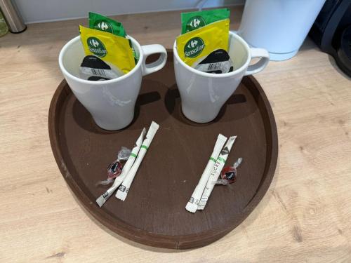 a table with two cups and toy figurines on it at Studio Mars NEW & Cozy - Parilly Train Station in Vénissieux