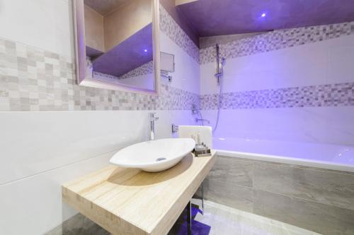 a bathroom with a white sink and a tub at Hotel Vespasiano in Rome