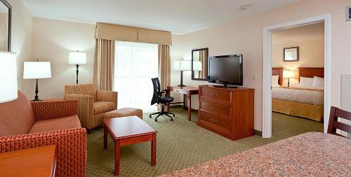 a hotel room with a bed and a living room at White River Inn & Suites in White River Junction