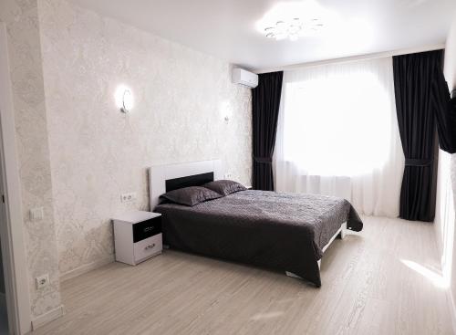 a bedroom with a bed and a window at Апартаменты Kadorr 59 in Odesa