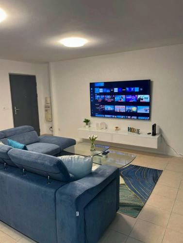 a living room with two blue couches and a tv at Élégance in Baie-Mahault