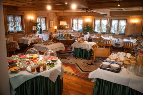 a dining room with tables and chairs with food on them at Landgasthof "Wilder Mann" in Innsbruck
