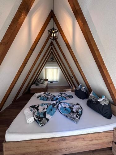 a attic bedroom with two beds in a roof at Vikendica Hamza in Bihać