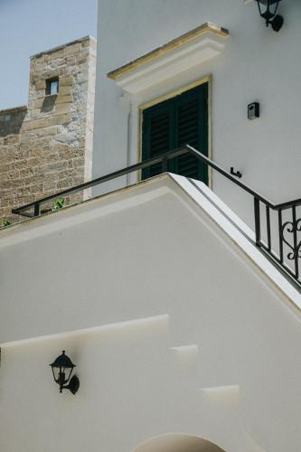 a stairway with a green door on a building at Angolo Laggetto Rooms in Otranto