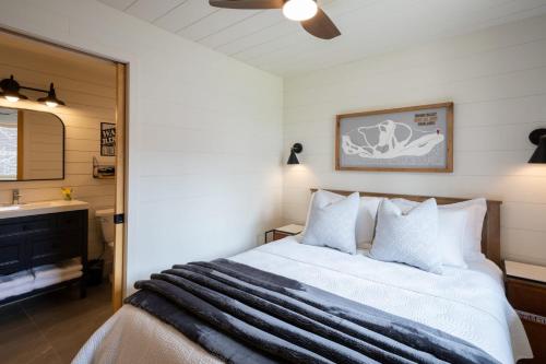 a bedroom with a bed with white sheets and a television at Muskoka Hutt in Huntsville