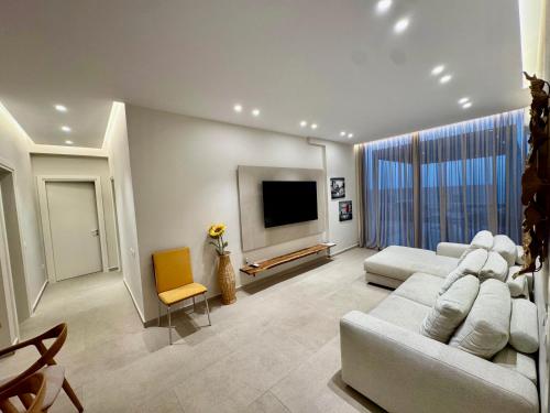a living room with two couches and a flat screen tv at TIS, Green Coast in Palasë