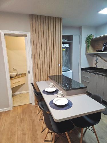a kitchen with a white table and chairs at Saint Sebastian Flat 716 - Com Hidro! até 3 pessoas, Duplex, no centro in Jaraguá do Sul