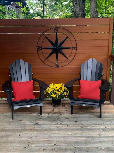 two chairs with red pillows sitting on a patio at Muskoka Hutt in Huntsville