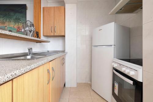 a kitchen with a sink and a refrigerator at SB Arenal in El Arenal