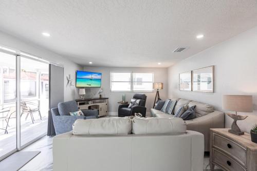 a living room with a white couch and a tv at Casa Blanca - VC16 in Siesta Key