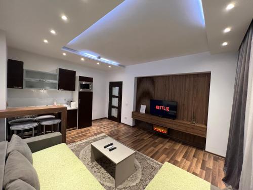 Una sala de estar con un sofá y un televisor. en Center City Apartment, en Pristina