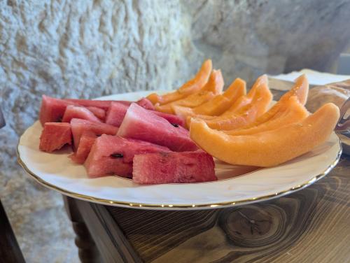 a plate of watermelon and other fruits on a table at Casa Avella Mountain Retreat in Pennapiedimonte