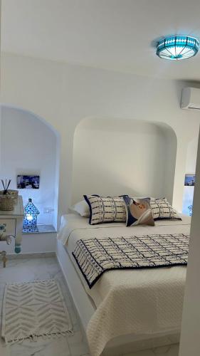 a white bedroom with two beds and a table at Dar Omi Aïcha 2 in Kerkouene