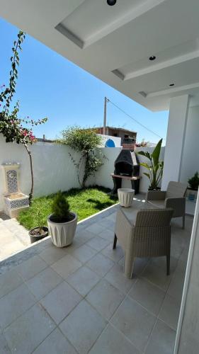 an outdoor patio with chairs and a fire pit at Dar Omi Aïcha 2 in Kerkouene