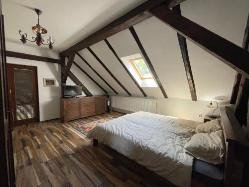 a bedroom with a large bed in the attic at Lovačka kuća Draganić in Draganići
