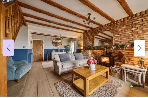 a living room with a couch and a fireplace at 1 Engine Row Beautiful 3 Bedroom Cottage in Penclawdd