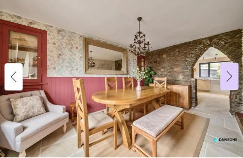 a dining room with a wooden table and chairs at 1 Engine Row Beautiful 3 Bedroom Cottage in Penclawdd