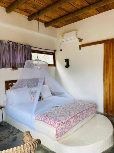 a bedroom with a white bed with a net at Casa Dibulla Hotel Boutique in Dibulla
