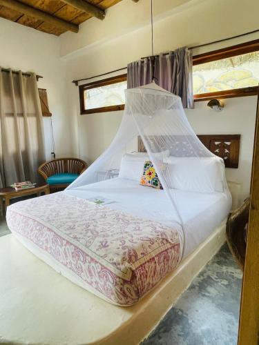 a bedroom with a large bed with a mosquito net at Casa Dibulla Hotel Boutique in Dibulla