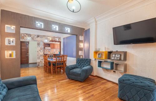 a living room with a couch and chairs and a television at casa de los espejos Av Cuauhtémoc in Mexico City