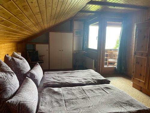 a bedroom with a bed and a large window at Haus Silverfern in Förolach