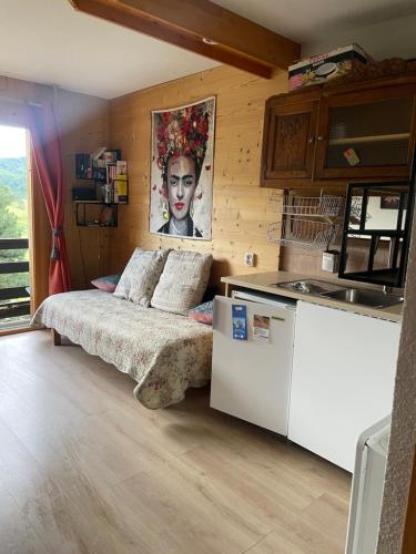 a bedroom with a bed in a room with a kitchen at Le ZEN au pied du Grand Veymont en été en hiver in Gresse-en-Vercors