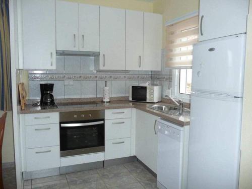 een keuken met witte kasten en een witte koelkast bij Bungalow with 2 bedrooms in Costa Calma